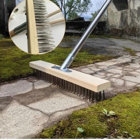 un-balai-brosse-métallique-nettoie-une-allée-de-mousse